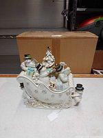 Front view of Lenox sleigh figurine and separate snowman