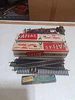 Lot overview showing track boxes, loose straight track pieces, fence panels, tractor, joiners