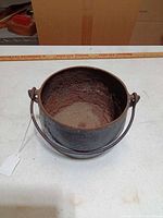 Top view of cast iron pot showing rusted interior and bail handle