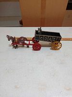 Full side view of cast iron horse, frame, and coal wagon