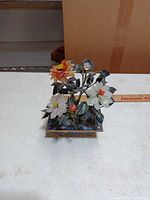 Front view of plastic flower arrangement in blue cloisonné pot