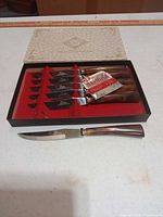 Open presentation box showing six knives and Sheffield tag