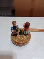 Top view of music box showing boy with instrument, small tree and gift