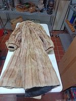 Full view of fur coat front side on table