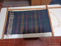 Full view of tapestry mounted on wooden poles