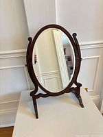 Front view of oval tabletop mirror on stand