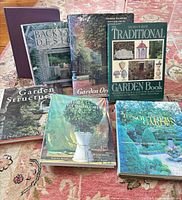Group shot of all six gardening books standing and lying on rug