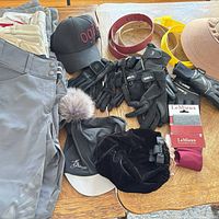 Assorted breeches, Ogilvy cap, belts, gloves, helmet covers laid out on table