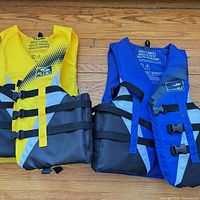 Front view of both Fluid life jackets showing colour and buckle arrangement