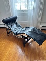 Full view of black leather chaise on base