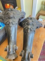 Two carved wooden piano legs side-by-side on table