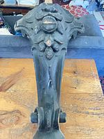 Top-down view showing carved floral motif and caster mount