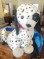 Front view of large white Dalmatian plush with black spots sitting on table