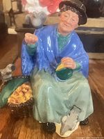 Front view of Royal Doulton figurine showing woman, pigeons, basket