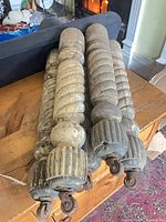 Five twisted wooden legs with casters laid on wooden surface