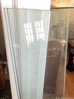 Edge view of stacked glass shelves showing polished edges and clarity