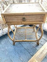 Front view of wicker rattan side table showing drawer and lower shelf
