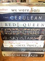 Stack of all nine young adult novels showing spines for title verification