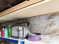 Overall view: cooler, water bottles, ceramic bowl, glass dish on shelf