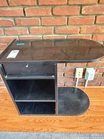 Front view showing drawer, two shelves, curved support base