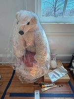 Stuffed polar bear under plastic, brushes, yarn ball, closed wooden box