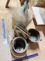 Top view showing demijohn mouth, both copper pots, trivet and vase placement