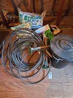 Garden hose coil, fertilizer bags, metal trash can