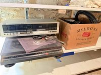 JVC cassette deck stacked on Onkyo turntable beside box of cables