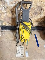 Front view of pressure washer with hose, wand and manual visible