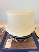 Three items stacked: white Tupperware cake container inverted over two glass bowls