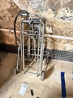 Both folded hand trucks leaning against wall