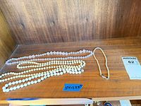 Four necklaces laid out on shelf