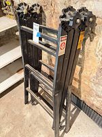 Ladder folded standing upright, showing rungs and adjustment knobs