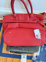 Red pebbled tote resting atop grey CPAP case, white plastic piece visible