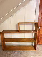 Front view of stepped 3-tier honey brown bookshelf