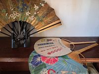 Folding sensu fan on stand with two uchiwa fans showing floral sides