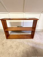 Front view of solid wood bookshelf showing two shelves and overall condition