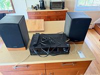 Front view of Sony receiver between two Advent speakers with remote and cables on top