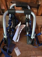 Folded Thule Gateway rack with blue straps and cradles visible