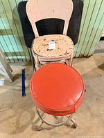 Front view showing red swivel stool in foreground, distressed pink stool and folding table behind
