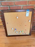 Front view of cork bulletin board with pins and clips