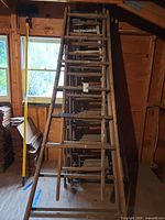 stacked wooden extension ladder with rungs visible