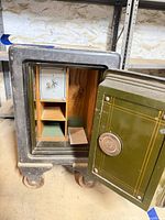 Safe open showing interior wooden shelves, green door panel, Yale emblem on inner door.