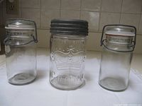 Three vintage glass canning jars displayed side by side