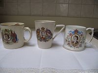 Front view of three commemorative mugs showing royal portraits and designs