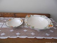 large square bowl and stacked small bowls on lace runner