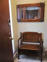 Hall bench beneath matching mirror with hooks