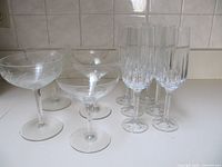 Group of six fluted champagne glasses, three plain coupe saucers, two etched coupe saucers
