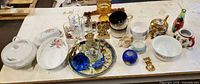 Overall lot on table showing assortment of glass, ceramic, figurines and serveware