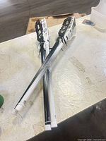 Three 30-inch black and white lacrosse sticks bundled together